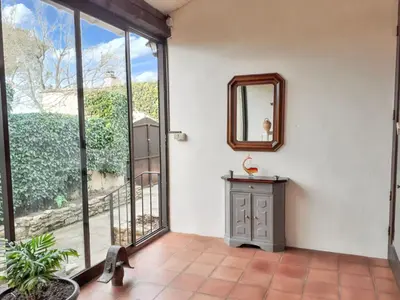 a room with large windows and a mirror at Maison avec piscine privée à Caromb, idéale pour famille in Caromb