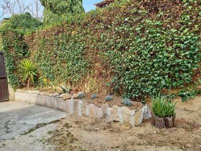 a garden with a retaining wall with plants at Maison avec piscine privée à Caromb, idéale pour famille in Caromb