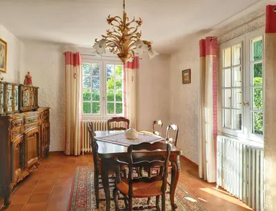 a dining room with a table and chairs and windows at Maison avec piscine privée à Caromb, idéale pour famille in Caromb