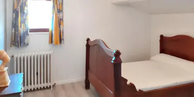 a small bedroom with a bed and a radiator at Maison avec piscine privée à Caromb, idéale pour famille in Caromb