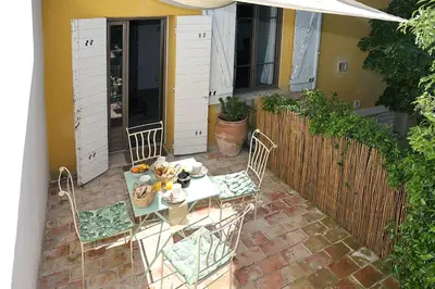 a patio with a table and chairs and a fence at Appartement Mas de Silvacane in La Roque-dʼAnthéron