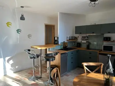 a kitchen with blue cabinets and a table and chairs at Appartement Mas de Silvacane in La Roque-dʼAnthéron