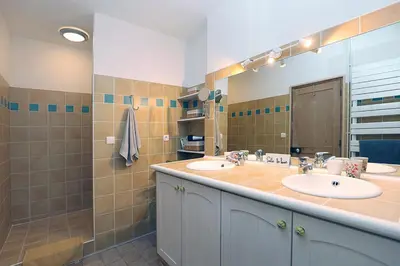 a bathroom with two sinks and a large mirror at Appartement Mas de Silvacane in La Roque-dʼAnthéron