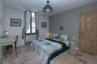a bedroom with a bed and a table and a desk at Appartement Mas de Silvacane in La Roque-dʼAnthéron
