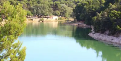 a view of a river with green water and trees at Belle maison provençale au pied du Mont Ventoux in Caromb