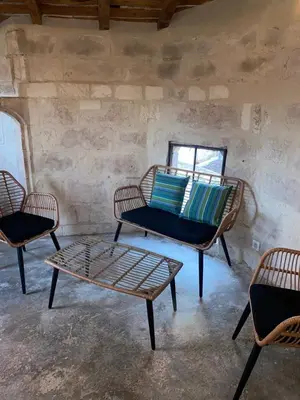 a room with three chairs and a table and a couch at La tour 2: Appart neuf au cœur de la petite venise in LʼIsle-sur-la-Sorgue