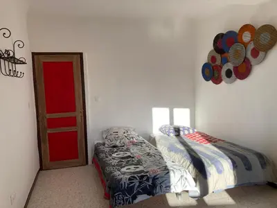 a bedroom with a bed and a red door at Pélissanne, superbe appartement entièrement rénové in Pélissanne