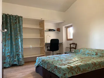 a bedroom with a bed and a desk and a chair at Pélissanne, superbe appartement entièrement rénové in Pélissanne