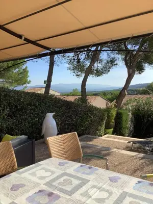 a table with chairs and a vase sitting on a patio at Les Oliviers in Mallemort