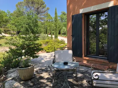 a chair sitting on a patio next to a window at les Bartavelles in Roussillon