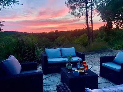 a patio with two chairs and a table with a sunset at les Bartavelles in Roussillon