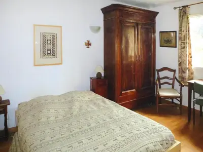 a bedroom with a bed and a wooden cabinet at Cozy Vacation House with Pool, Vernègues in Vernègues