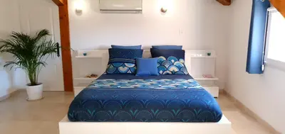 a bedroom with a blue bed with blue pillows at Maison calme et rénovée 