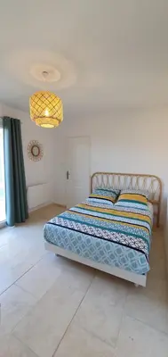 a bedroom with a bed and a chandelier at Maison calme et rénovée 