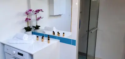 a bathroom with a shower and a sink with towels at Maison calme et rénovée 