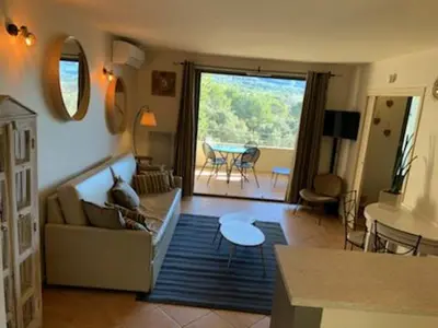 a living room with a couch and a table at appartement cosy avec climatisation réversible GOLF DE SAUMANE in Saumane-de-Vaucluse