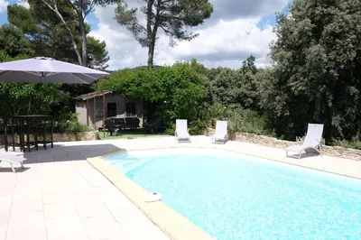 a swimming pool with two chairs and an umbrella at villa with pool and beautiful view in the luberon in pujet sur durance - 10 in Puget