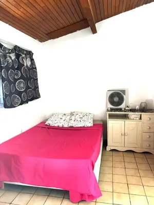 a bedroom with a red bed and a kitchen at Appartement charmant à Avignon - 50 m² - Terrasse privée in Avignon