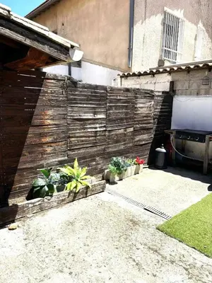 a backyard with a wooden fence and some plants at Appartement charmant à Avignon - 50 m² - Terrasse privée in Avignon