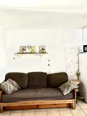 a couch in a room with a white wall at Appartement charmant à Avignon - 50 m² - Terrasse privée in Avignon