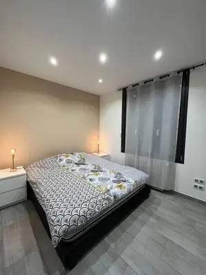 a bedroom with a large bed in a room with windows at Logement privé à proximité du Mont Ventoux in Carpentras