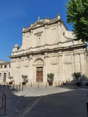 a large stone building with a clock on it at Le Nid'Isle - Stationnement privé gratuit - Wi-Fi performant - Climatisation in LʼIsle-sur-la-Sorgue