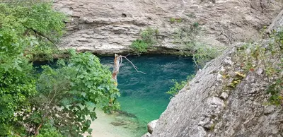 a cave in the side of a mountain with blue water at Le Nid'Isle - Stationnement privé gratuit - Wi-Fi performant - Climatisation in LʼIsle-sur-la-Sorgue