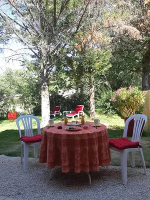 a table with a red tablecloth and two chairs with candles on it at Bastide Cedrea in Peyrolles-en-Provence