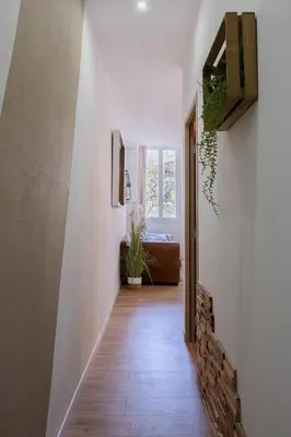 a hallway with white walls and a wooden floor and a stairway at Woods Natural Hyper centre Fontaine Moussue in Salon-de-Provence
