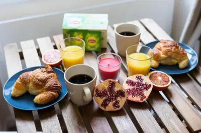 a table with two plates of croissants and glasses of orange juice at Exotic Stones Hyper Centre Fontaine Moussue in Salon-de-Provence