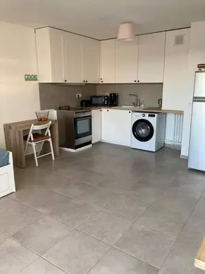 a kitchen with a refrigerator and a dishwasher at Appartement RDC avec parking privé in La Fare-les-Oliviers