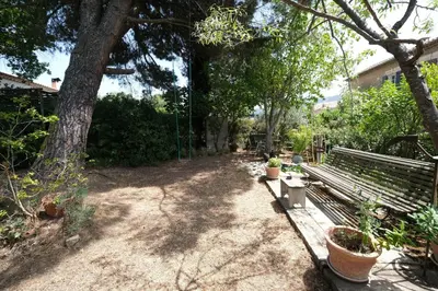 a wooden fence in the middle of a garden at jolie location, maison avec piscine et joli jardin fleuri, à oppède dans le luberon en provence – 6 personnes in Oppède