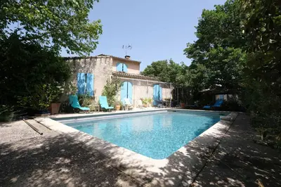 a yard with a bench and a tree at jolie location, maison avec piscine et joli jardin fleuri, à oppède dans le luberon en provence – 6 personnes in Oppède