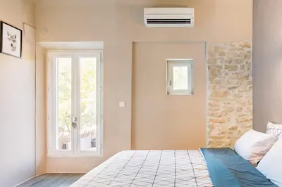 a bedroom with a bed and a window at appartement de charme dans le luberon in Lagnes