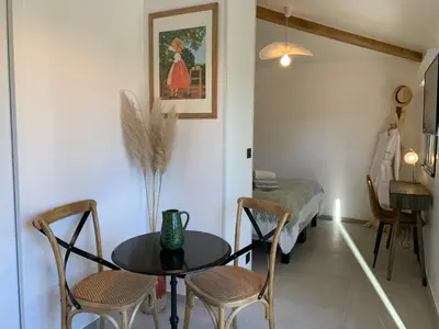 a room with a table and chairs and a bed at La Parenthese Saint Donat in Aix-en-Provence