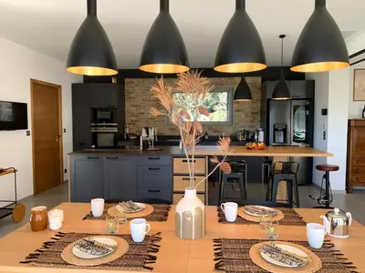 a kitchen with a wooden table with plates on it at La Parenthese Saint Donat in Aix-en-Provence