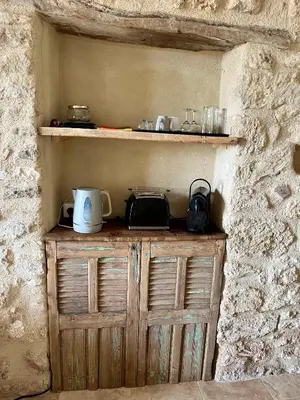 a wooden cabinet in the corner of a stone wall at La Verrière à Bonnieux in Bonnieux