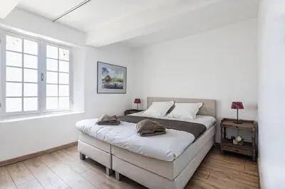 a white bedroom with a large bed and a window at Pavillon Lou in Crillon-le-Brave