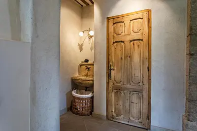 a bathroom with a wooden door and a sink at Pavillon Lou in Crillon-le-Brave