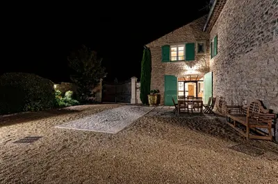a stone house with two benches in front of a building at Pavillon Lou in Crillon-le-Brave