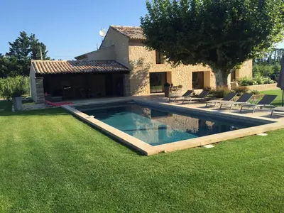 a swimming pool in the yard of a house at MAS DE CHARME EN PROVENCE in Le Thor