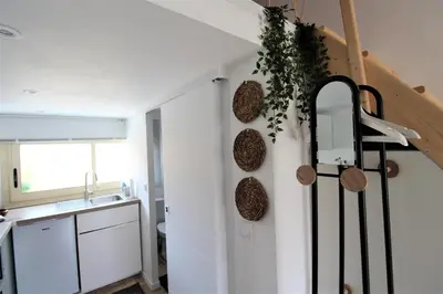 a kitchen with white cabinets and a staircase with a sink at Les Bastidons de L'Isle - st ju- 3 étoiles in LʼIsle-sur-la-Sorgue