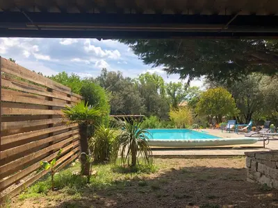 a swimming pool in a yard next to a fence at LUBERON DES ARTISTES 2 in Apt