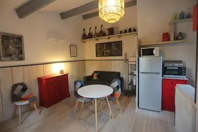 a kitchen with a white table and a white refrigerator at LUBERON DES ARTISTES 2 in Apt