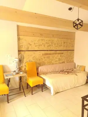 a bedroom with a bed and two yellow chairs at Sous un chêne bicentenaire in Lambesc