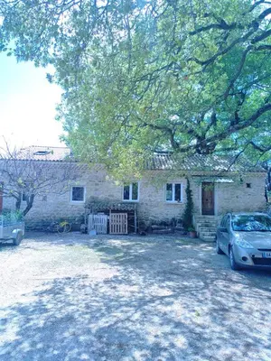 a stone house with a car parked in front of it at Sous un chêne bicentenaire in Lambesc