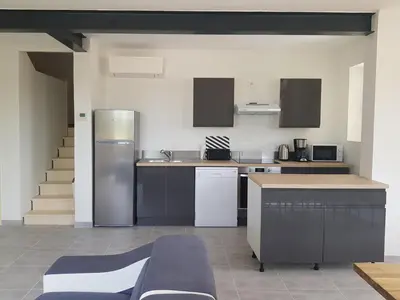 a kitchen with a stainless steel refrigerator in a room at Domaines des confines in Monteux