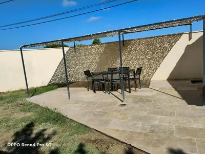a patio with a table and chairs in front of a wall at Domaines des confines in Monteux