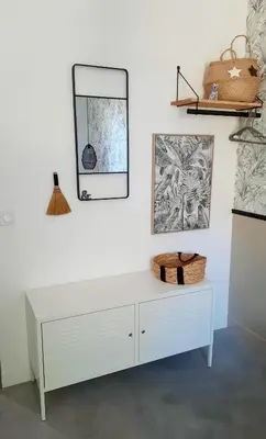 a white dresser against a white wall with a mirror at Gîte des Bartavelles in Saint-Didier