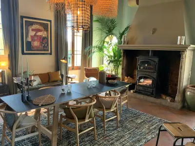 a living room with a table and a fireplace at La Bastide des Grands Chênes in Lambesc